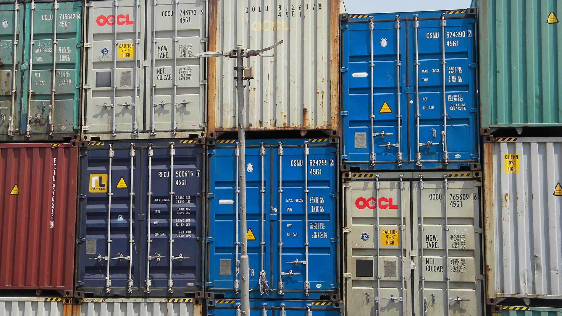 A wall of stacked container doors, seals and markings visible.